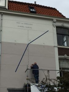 De wet van Snellius op een muur aan de Hooigracht. De muur was al tweekleurig en was daarom de perfecte plek om de breking van licht in water weer te geven.